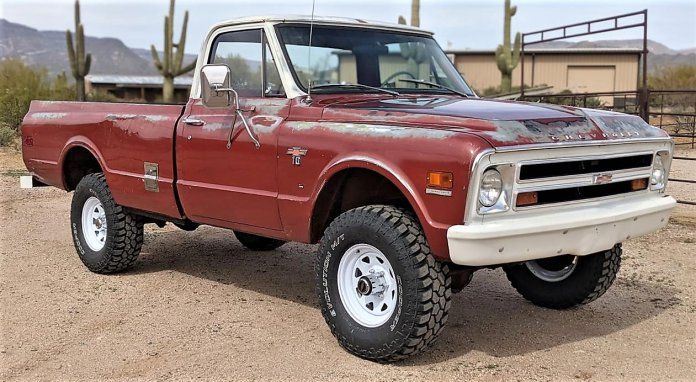 a red pick up truck parked in the dirt