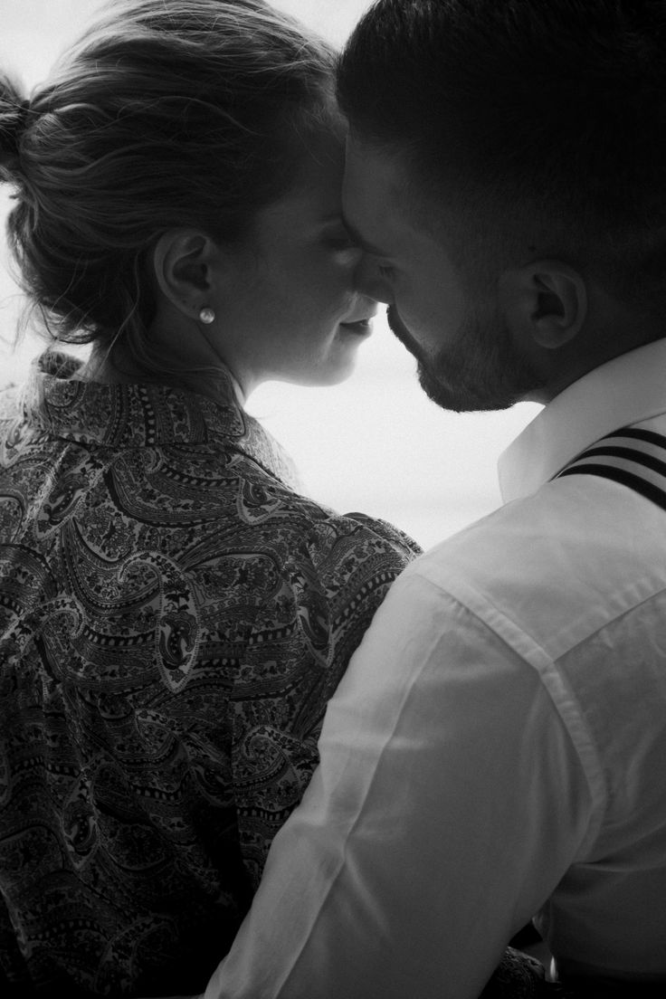 a man and woman kissing each other in black and white