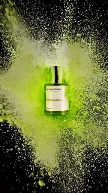 a bottle of green liquid is sprinkled with white powder on a black background