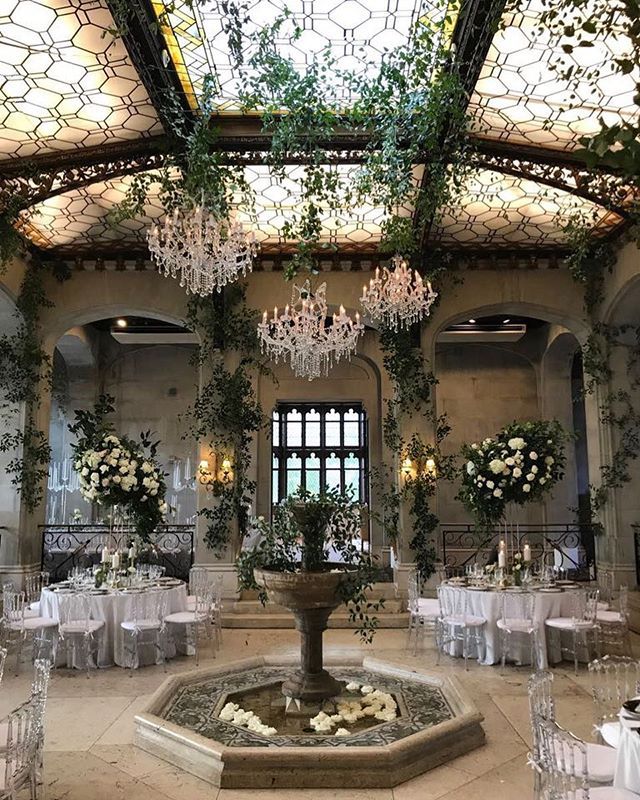 the wedding venue is decorated with greenery and chandeliers