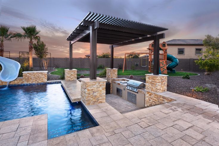 a backyard with a swimming pool and grill area