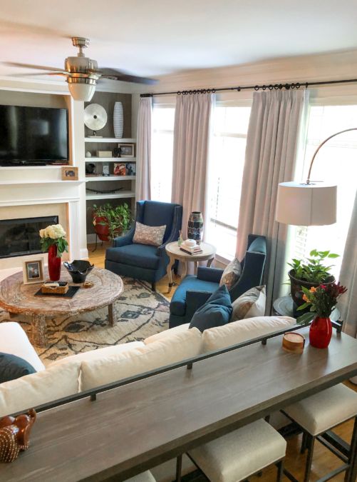 a living room filled with furniture and a flat screen tv mounted on the wall above a fireplace