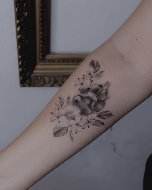 a woman's arm with flowers and leaves tattooed on the left side of her arm