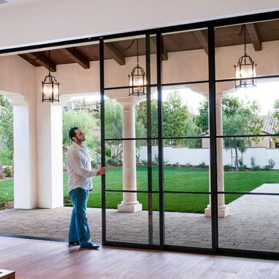 a woman standing in front of a sliding glass door with an open screen on it