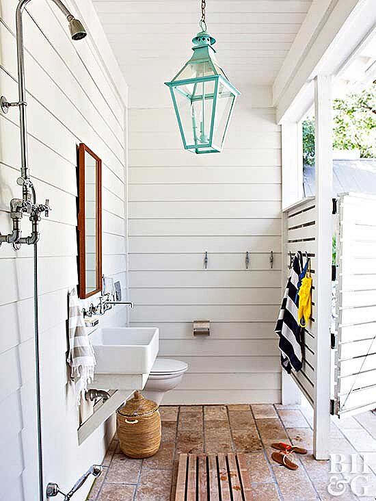 a white bathroom with wood flooring and a lantern hanging from the ceiling above it