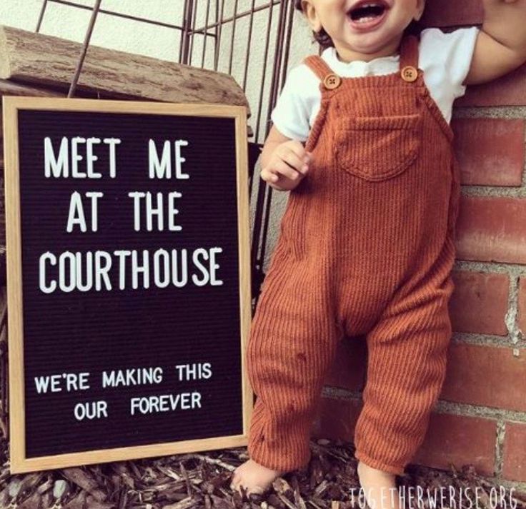 a baby standing next to a sign that says meet me at the courthouse we're making this our forever