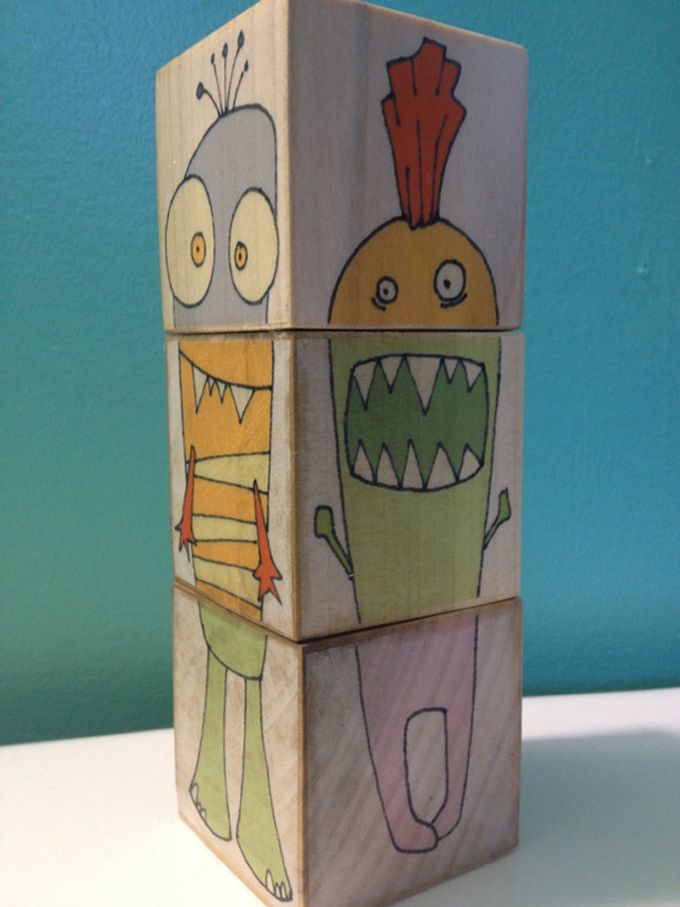 a wooden block with two cartoon characters on it's sides and one has an open mouth