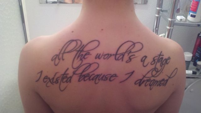 the back of a man's shoulder with writing on it that says, all the world is a stage