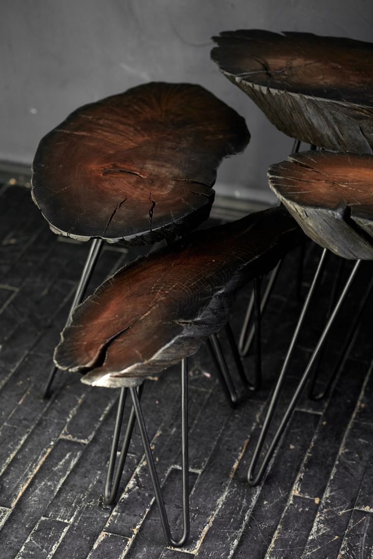 three wooden chairs sitting on top of metal legs