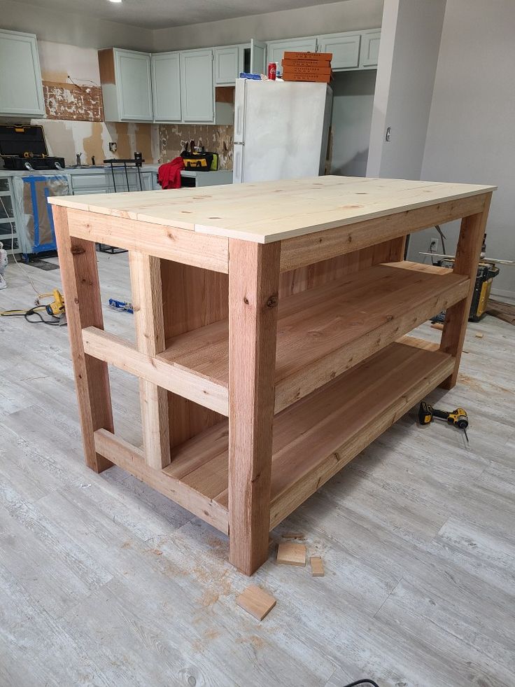 a kitchen island made out of wooden planks in the middle of a room with hard wood flooring