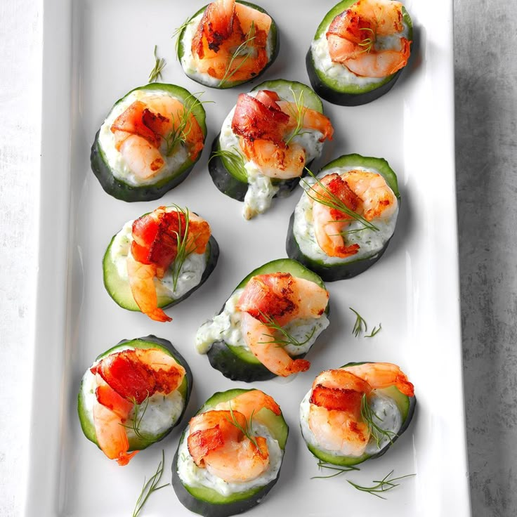 small stuffed cucumbers with shrimp and cream cheese on them are served on a white platter