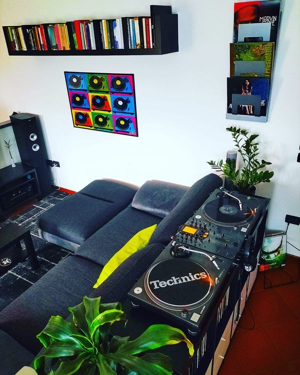 a living room with a couch, table and dj equipment