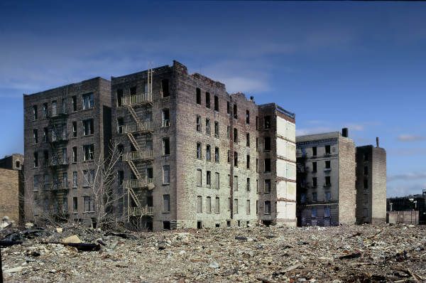 an old abandoned building surrounded by rubble in the middle of a city with blue sky