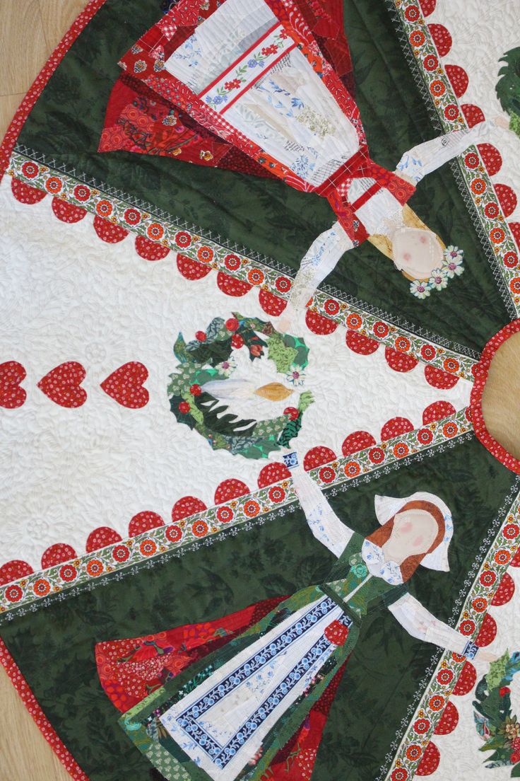 a quilted table topper with an image of a woman holding a christmas wreath