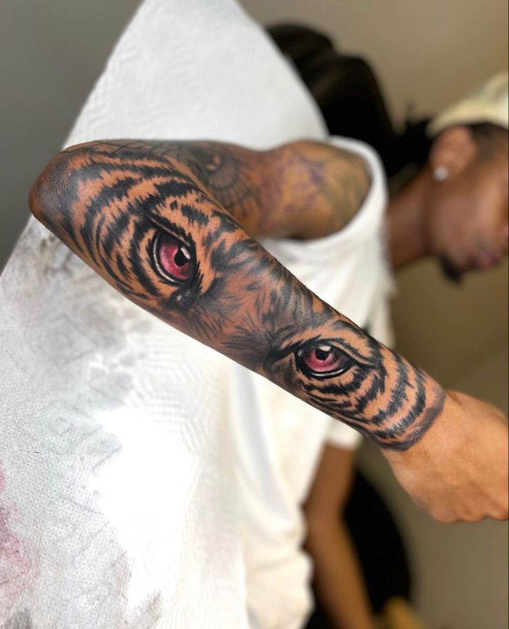 a man's arm with a tiger tattoo on it and red eyes in the center