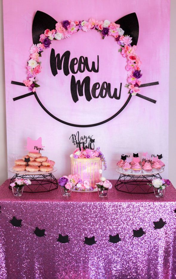 a table topped with cakes and cupcakes next to a sign that says meow meow