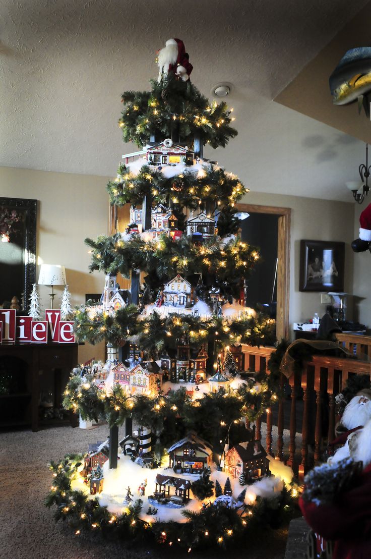 a christmas tree is decorated with lights and ornaments in the shape of a train set