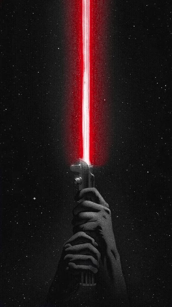 a person holding a cell phone in front of a red light saber on a black background