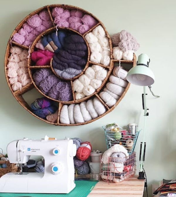 a sewing machine sitting on top of a table next to a basket filled with yarn