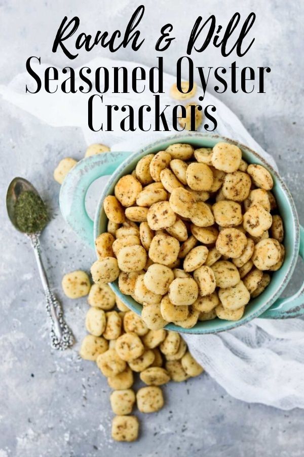 ranch and pill seasoned oyster crackers in a blue bowl with a spoon next to it