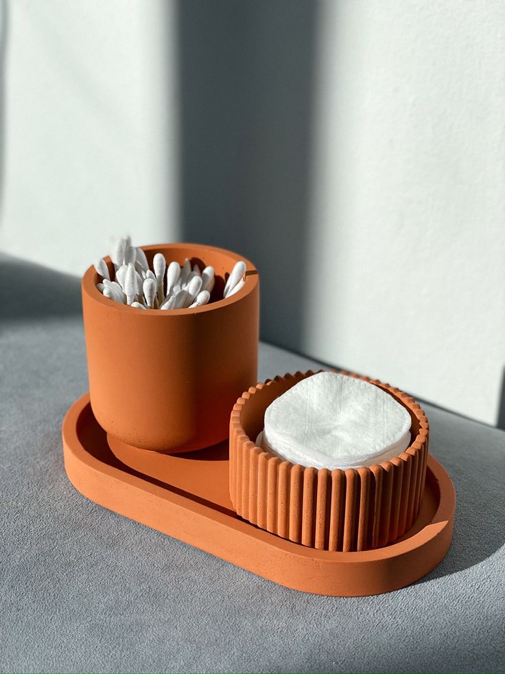 two clay pots with white powder in them sitting on a tray next to each other