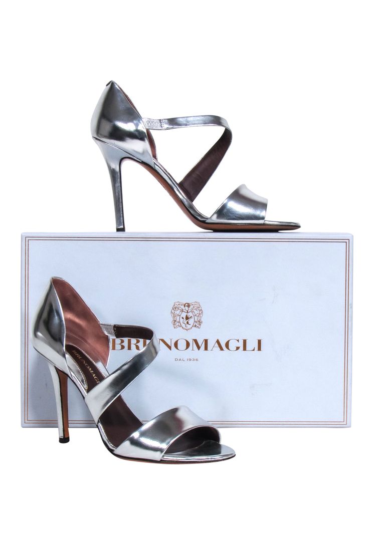 Take your style game up a notch with these silver metallic Brunomagli pumps! With their open toe and wrap around detail, it will be a night to remember! Style them with a little black dress to set off the evening with a spark! Size 6.5 (IT 36.5) Made in Italy 100% Leather Slip on Open toe Comes with dustbag and box Heel height 4" Chic Metallic Silver Heels With Heel Strap, Chic Metallic Party Sandals, Metallic Open Heel Sandals For Night Out, Chic Metallic Open Toe Heels, Chic Metallic Heels For Gala, Metallic Pointed Toe Sandals For Evening, Metallic Pointed Toe Evening Sandals, Silver Sandals With 4-inch Heel, Metallic Heels For Spring Gala