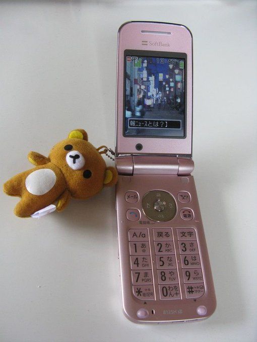 a pink cell phone sitting next to a stuffed animal