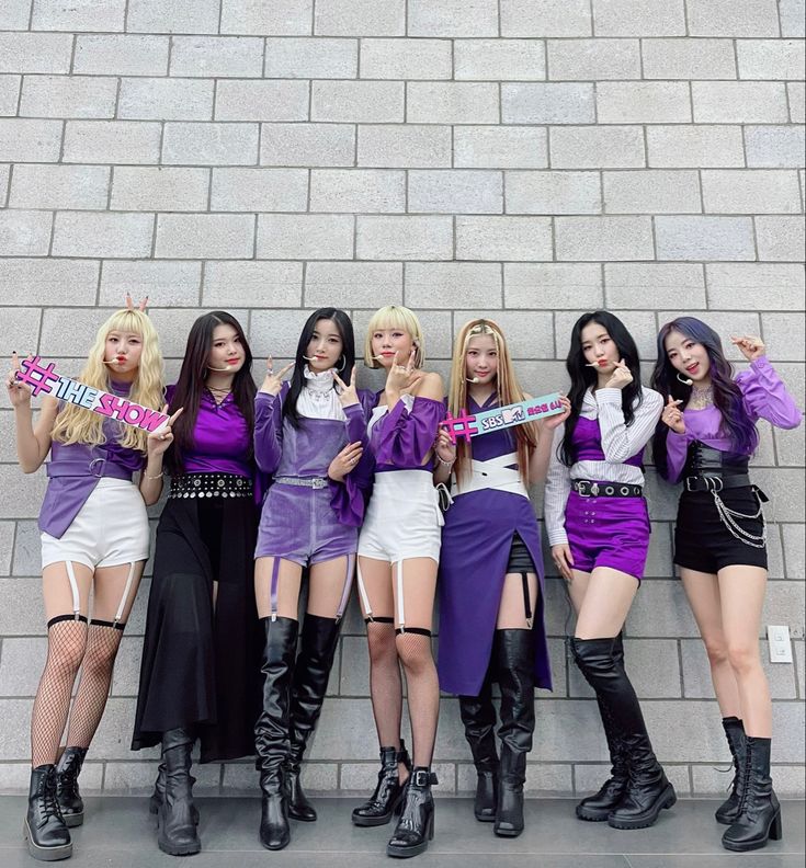 the girls are posing in front of a brick wall with their name sashes on