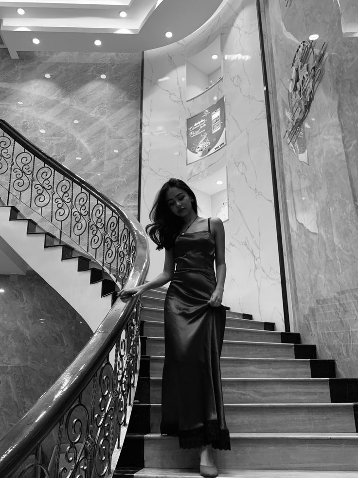 a woman in a dress standing on some stairs