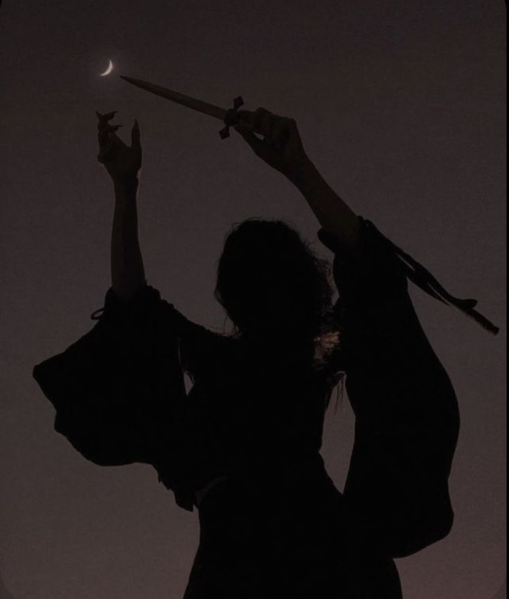 the silhouette of two people holding up their arms in the air, with one person reaching for the moon