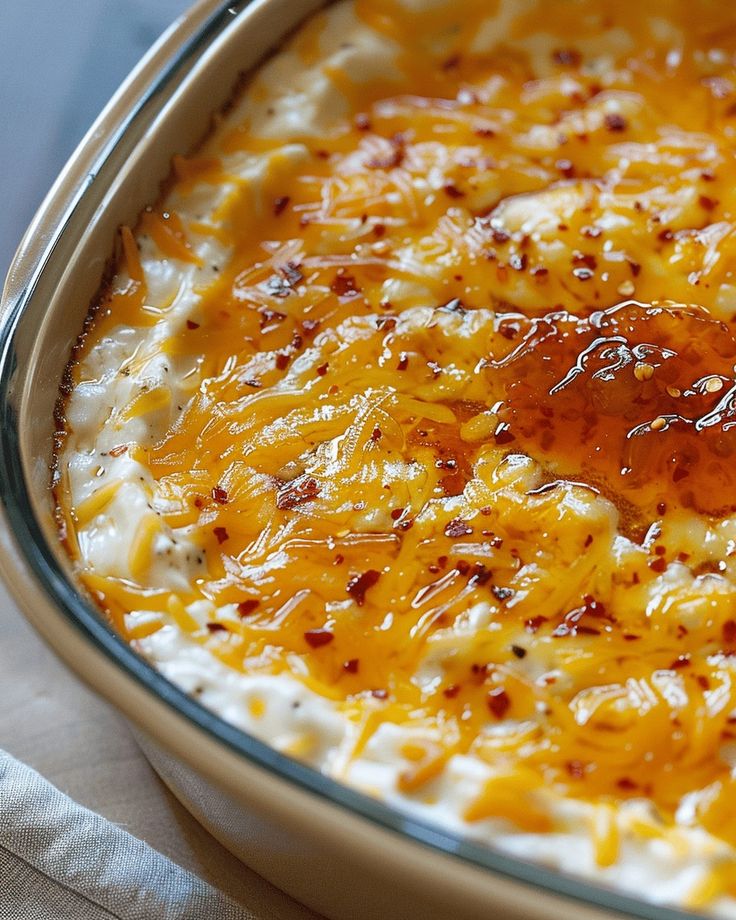 a casserole dish with cheese and sauce in it