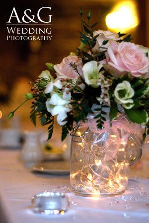 a vase filled with pink and white flowers on top of a table