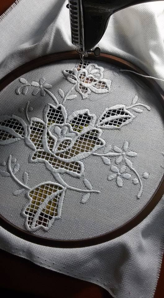 a close up of a embroidery on a piece of cloth with scissors in the background