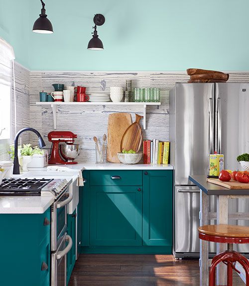 a kitchen with teal cabinets and wooden floors