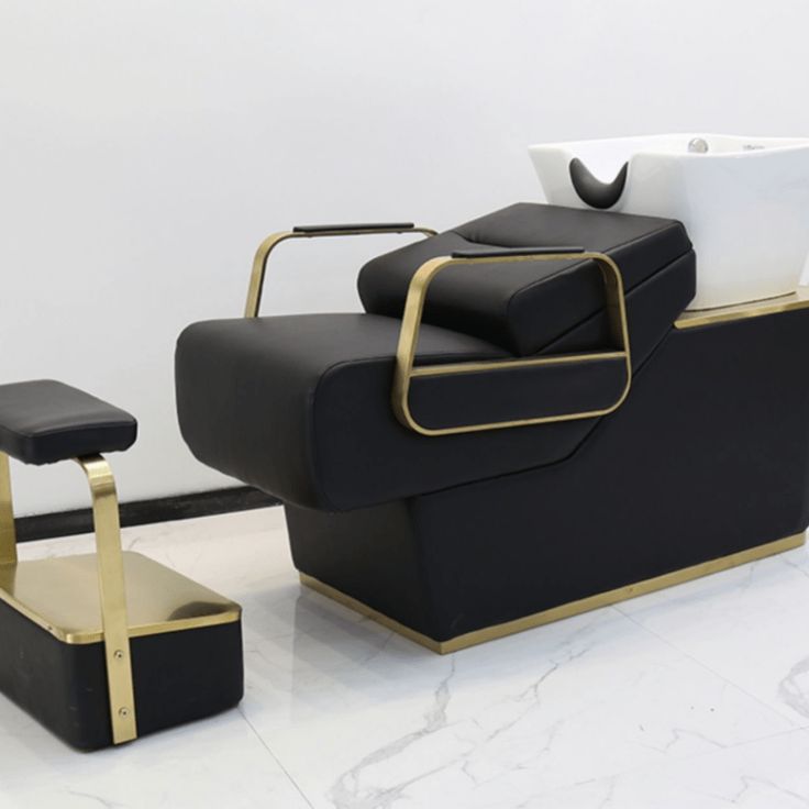 a black and gold reclining chair next to a white wall with the yocell logo on it