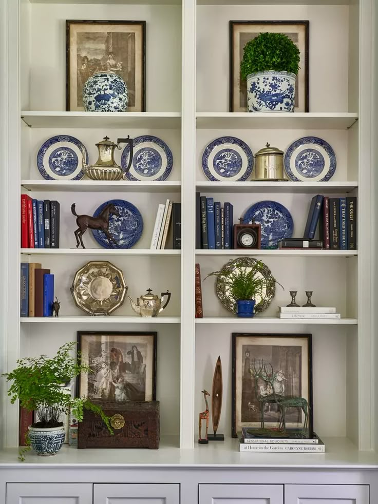 a white bookcase with blue and white plates on it