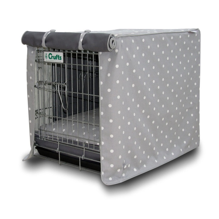 the dog crate cover is grey with white polka dots and has a black mat on it