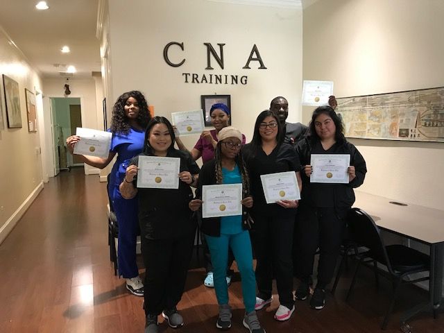 a group of women standing next to each other holding diplomas in front of a wall