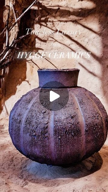 a large purple vase sitting on top of a dirt ground