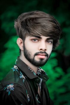 a man with a goatee and flowered shirt looks at the camera while posing for a portrait