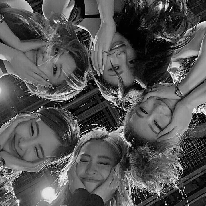 black and white photograph of four girls with their arms around each other's shoulders