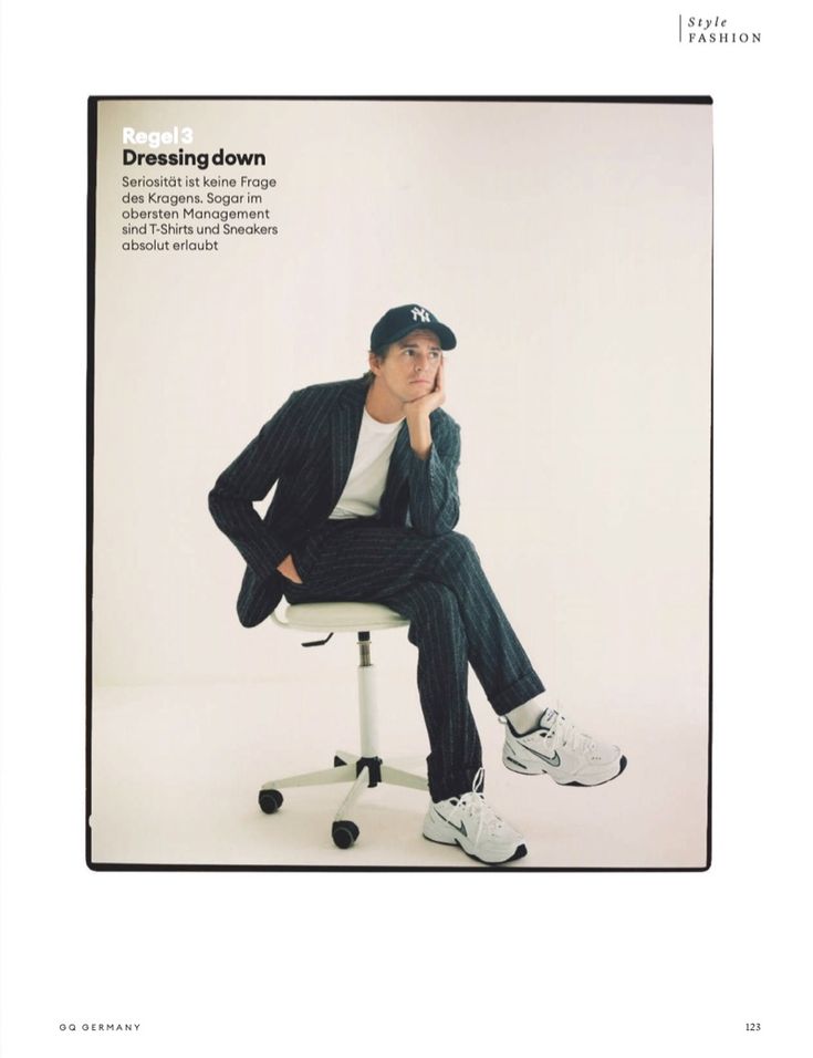 a man sitting on top of a white chair next to a black and white photo