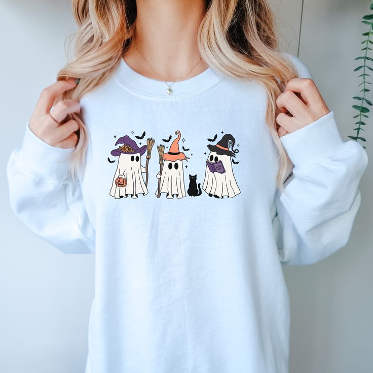 Get ready for Halloween with our Witchy Ghosts Sweatshirt! Featuring adorable ghosts dressed as witches, this cozy sweater will keep you warm while spreading spooky vibes. Perfect for those who love cute and playful Halloween fashion. Fall Costume Party Long Sleeve Tops, Long Sleeve Tops For Costume Party, Fall, Long Sleeve Tops For Costume Party In Fall, Fun Fall Loungewear Tops, Long Sleeve Cotton Halloween Sweater, Cotton Long Sleeve Halloween Sweater, Long Sleeve Cotton Sweater For Halloween, Halloween Long Sleeve Loungewear Sweatshirt, Long Sleeve Cotton Tops For Costume Party