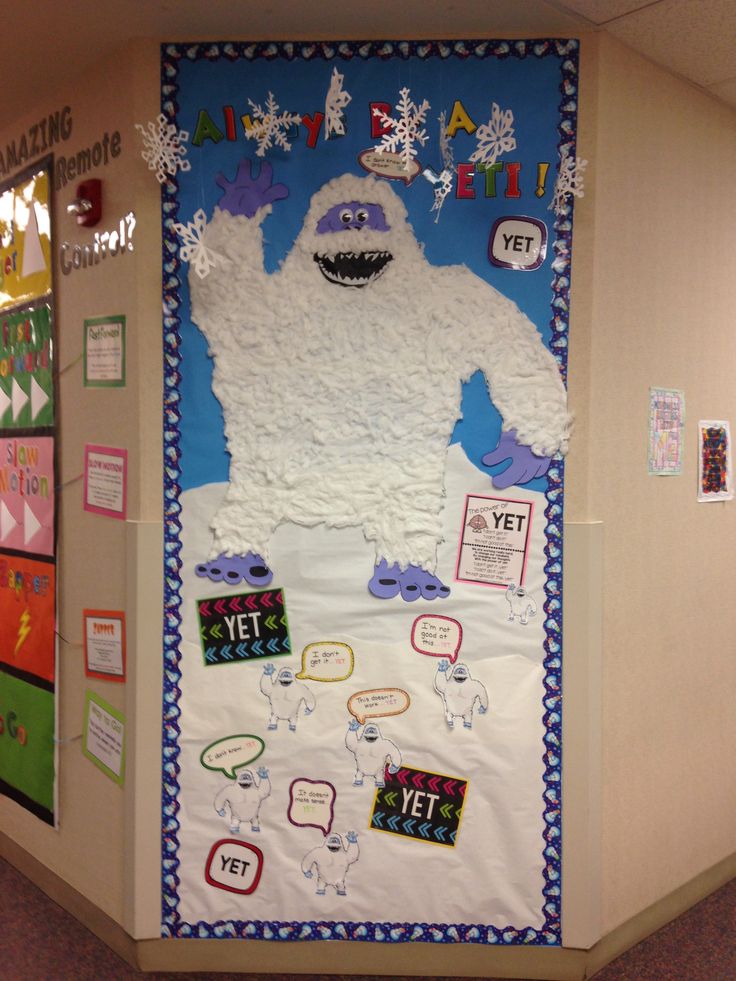 a bulletin board decorated with an image of a monster and snowflakes on it