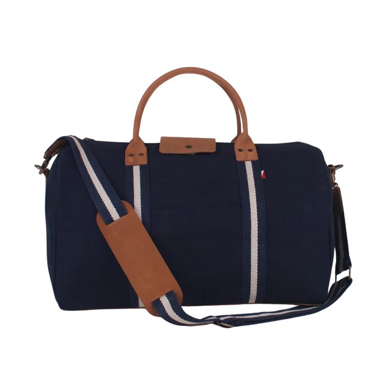 This duffle is a perfect size to bring as a carry-one or in addition to your other bags. There's a handy trolly slip on the back so it slips easily over your rollie-bag handles. With a full leather bottom and details, this bag will add some style back to your travels! Matching travel kits also available. (The Natural bag has black /natural striped webbing). This item can also be monogrammed!Product Overview: Dimensions: 18" x 10" x 10" with a 6" handle drop, 55" adjustable / detachable strap Hea Everyday Rectangular Duffle Bag With Leather Trim, Weekend Tote Duffle Bag With Leather Handles, Travel Weekender Bag With Coated Canvas Handles, Weekend Duffle Bag With Leather Handles, Rectangular Duffle Bag With Leather Trim For Weekend Trips, Leather Handle Tote Luggage For Weekend Trips, Leather Handle Tote Duffle Bag For Weekend Trips, Rectangular Luggage With Leather Trim For Everyday Use, Daily Use Duffle Bag With Leather Handles