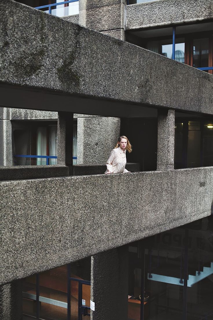 a woman standing on the ledge of a building