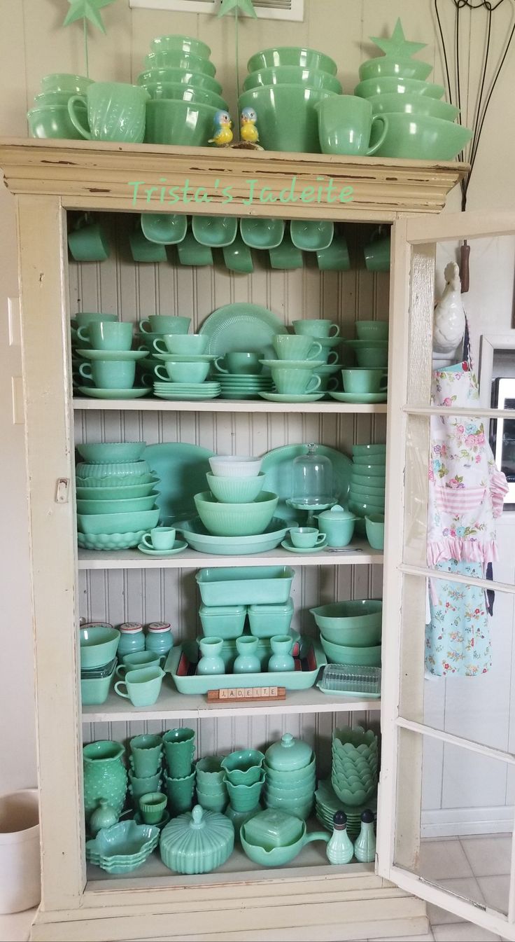 a cabinet filled with lots of green dishes