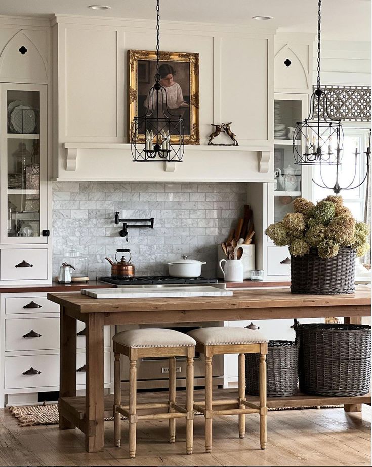 a kitchen with white cabinets and an island in front of the stove top, surrounded by wicker baskets