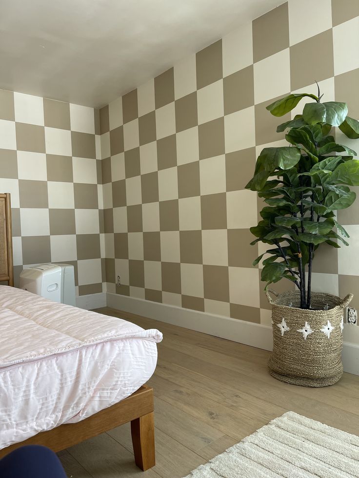 a bed sitting next to a potted plant in a bedroom