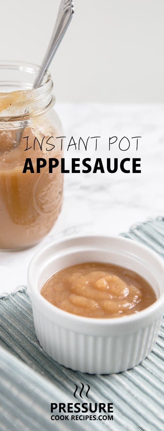 an apple sauce in a small white bowl next to a glass jar filled with apples